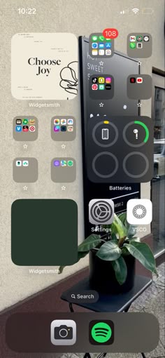 an image of a cell phone with different icons on the screen and in front of it is a potted plant