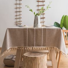 a wooden table with a vase on top of it next to a tree stump stool