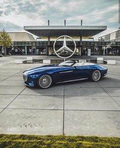 a blue convertible car parked in front of a mercedes dealership