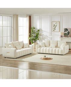 a living room filled with white furniture next to a fire place in a fireplace mantel