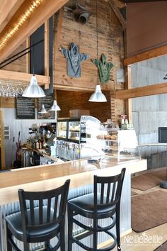 the interior of a restaurant with bar stools and wood paneled wall behind it