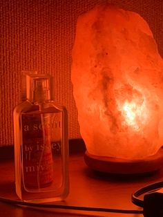 a himalayan salt lamp next to an empty bottle