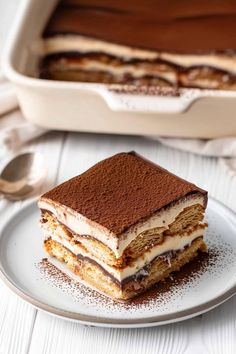 a piece of cake sitting on top of a white plate next to a pan filled with dessert