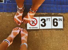 two people standing next to each other near a sign that says 3 feet in no diving