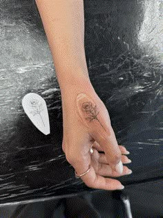 a woman's hand with a rose tattoo on it