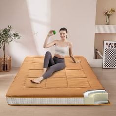 a woman is sitting on an inflatable mattress and holding a green ball above her head