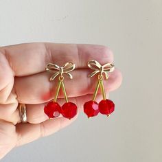 Description Crystal Cherry Earrings   Rock the quirky trend with these handmade Crystal Cherry Earrings featuring a cute gold-plated bow stud. Perfect for any season, these beauties add a playful touch to any outfit.     Details  * Length: 1.5 Inch; Width: 0.5 Inch (approx.)  * Materials: Crystal beads and gold plated bow stud earrings   * Location: Earlobe  * Closure: Push back  * Style: Boho & hippie This is a limited edition handmade by Soane from our studio in Calgary. Cherry Earrings, Earrings Beaded, Wedding Jewelry Earrings, Acrylic Earrings, Brass Earrings, Style Boho, Wedding Earrings, Boho Hippie, Outfit Details