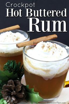 two glasses filled with hot buttered rum and topped with cinnamon sticks