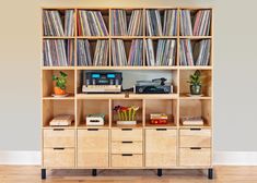 an old record player is sitting on top of a bookcase filled with vinyl records