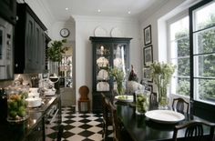 a black and white checkered floor in a dining room with lots of windows, cabinets and chairs