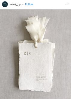 a piece of paper with the word kiss written on it and a flower attached to it