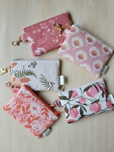 four small zippered pouches sitting on top of a wooden table next to each other