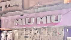 the front of a building with newspaper covering it's windows and letters that read, umum