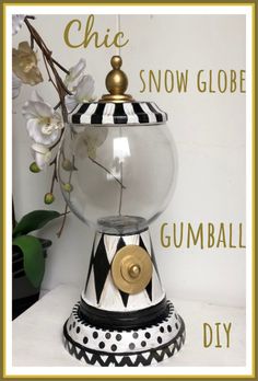 the gumball dispenser is decorated with black and white stripes, gold accents