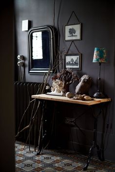 a wooden table topped with sculptures and framed pictures