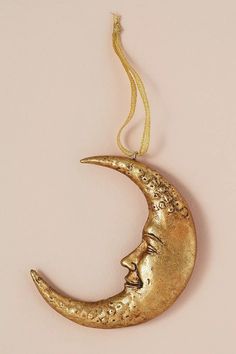 a gold crescent moon ornament hanging on a string