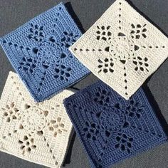 four crocheted squares are sitting on the floor, one is blue and one is white