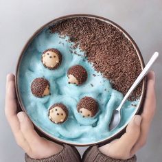 a person holding a bowl filled with desserts in the shape of hedgehogs