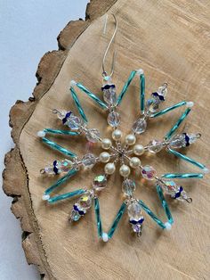 a snowflake ornament made out of glass beads and swaroons