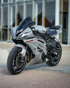 a silver and black motorcycle parked in front of a building