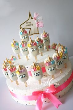 a white cake topped with lots of little unicorns