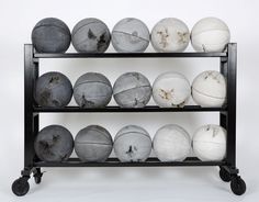 there are many balls on the black rack and one is white, gray and grey