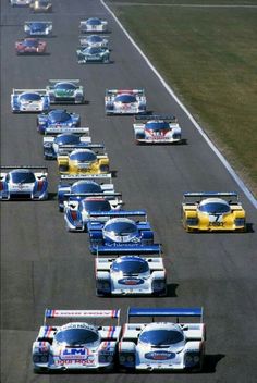 a group of cars driving down a race track with the number 1 on each side