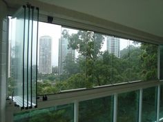 an open window with the view of trees and buildings in the backgrouds