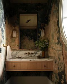 a bathroom with a marble counter top next to a mirror and sink under a window