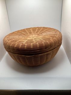 a large woven basket sitting on top of a white surface