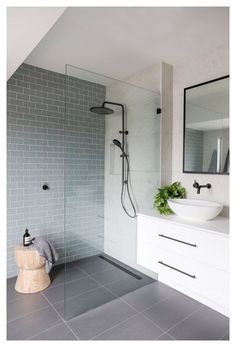 a bathroom with a sink, mirror and shower head in it's center wall