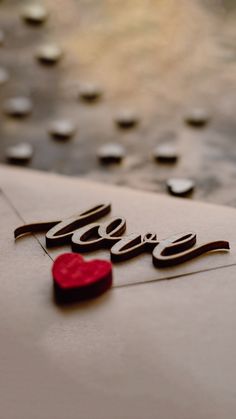 the word love written in cursive writing on a piece of paper with a red wax stamp