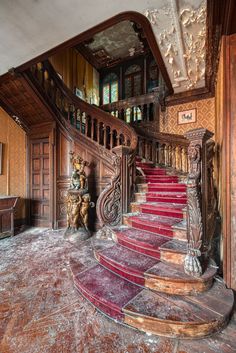 an ornate wooden staircase with red carpet