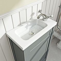 a white sink sitting under a faucet in a bathroom