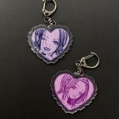 two heart shaped key chains with anime characters on them, one is pink and the other is purple