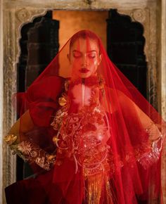 a woman in a red dress and veil