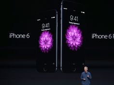 steve jobs standing in front of two iphones