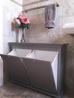 a gray cabinet with two bins and flowers in it