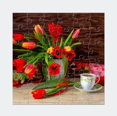 a jigsaw puzzle with red and yellow tulips in a vase next to a coffee cup