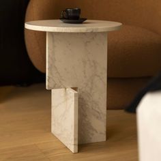 a marble table with a cup on it and a brown chair in the back ground