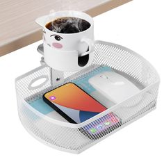 a coffee cup holder with a phone and other items in it on a white table