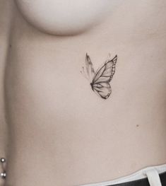 a woman's stomach with a butterfly tattoo on the side of her belly,