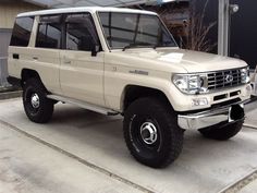 a white toyota pickup truck parked in front of a building with no doors on it