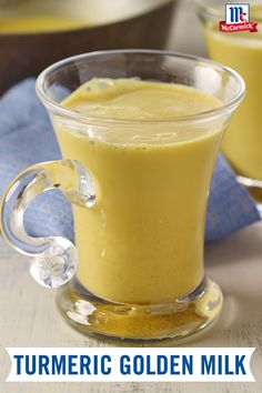 a glass cup filled with yellow turmeric milk