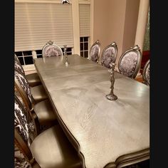 a long table with chairs around it in the middle of a dining room set up