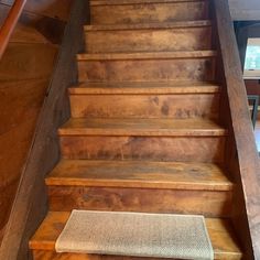 a wooden stair case with carpet on the bottom