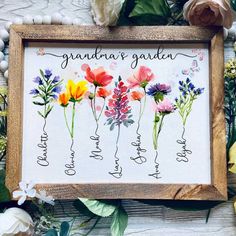 a wooden frame with flowers on it and the words grandma's garden written in cursive writing