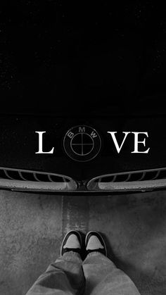 someone is standing in front of a bmw car with the word love written on it