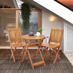 two wooden chairs and a table on a deck