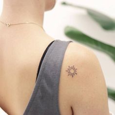 a woman with a small sun tattoo on her shoulder